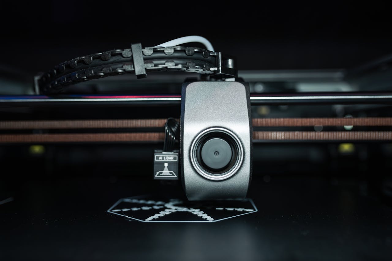 Home Detailed close-up of a 3D printer extrusion head in focus, showcasing modern technology.